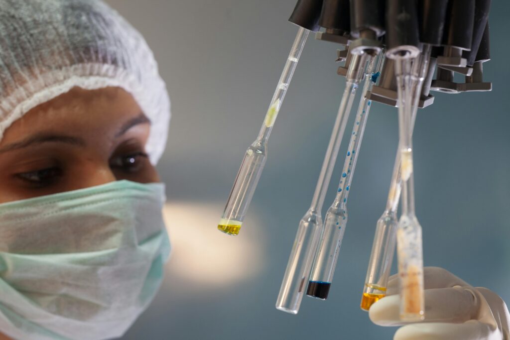 Woman scientist in lab handling test tubes with precision and focus.
